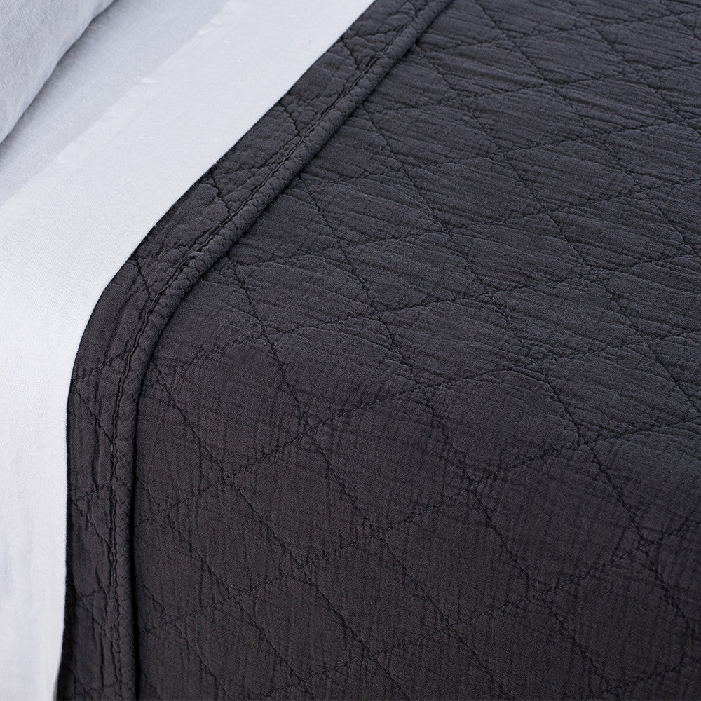 Dark grey POM POM Huntington King coverlet with diamond quilting on bed, white sheets, modern bedroom style.