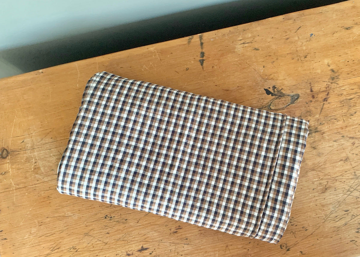 Folded white king duvet by Modernplum on rustic wooden surface, minimalist style, perfect for bedrooms.