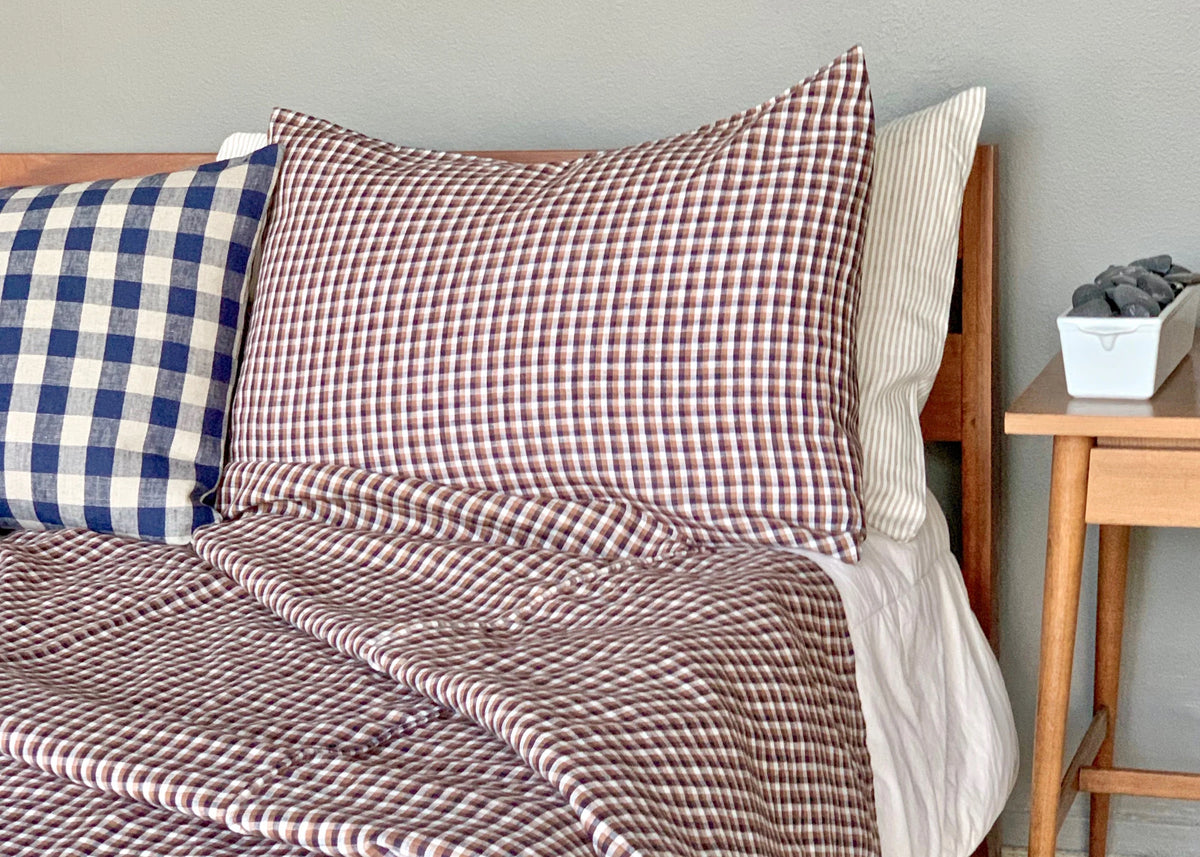 Hertford King Duvet by Plum Textiles in check linen, styled on bed with pillows and wood nightstand.