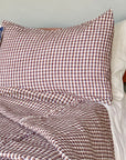 Hertford King Duvet by Plum Textiles in check linen, styled on bed with pillows and wood nightstand.