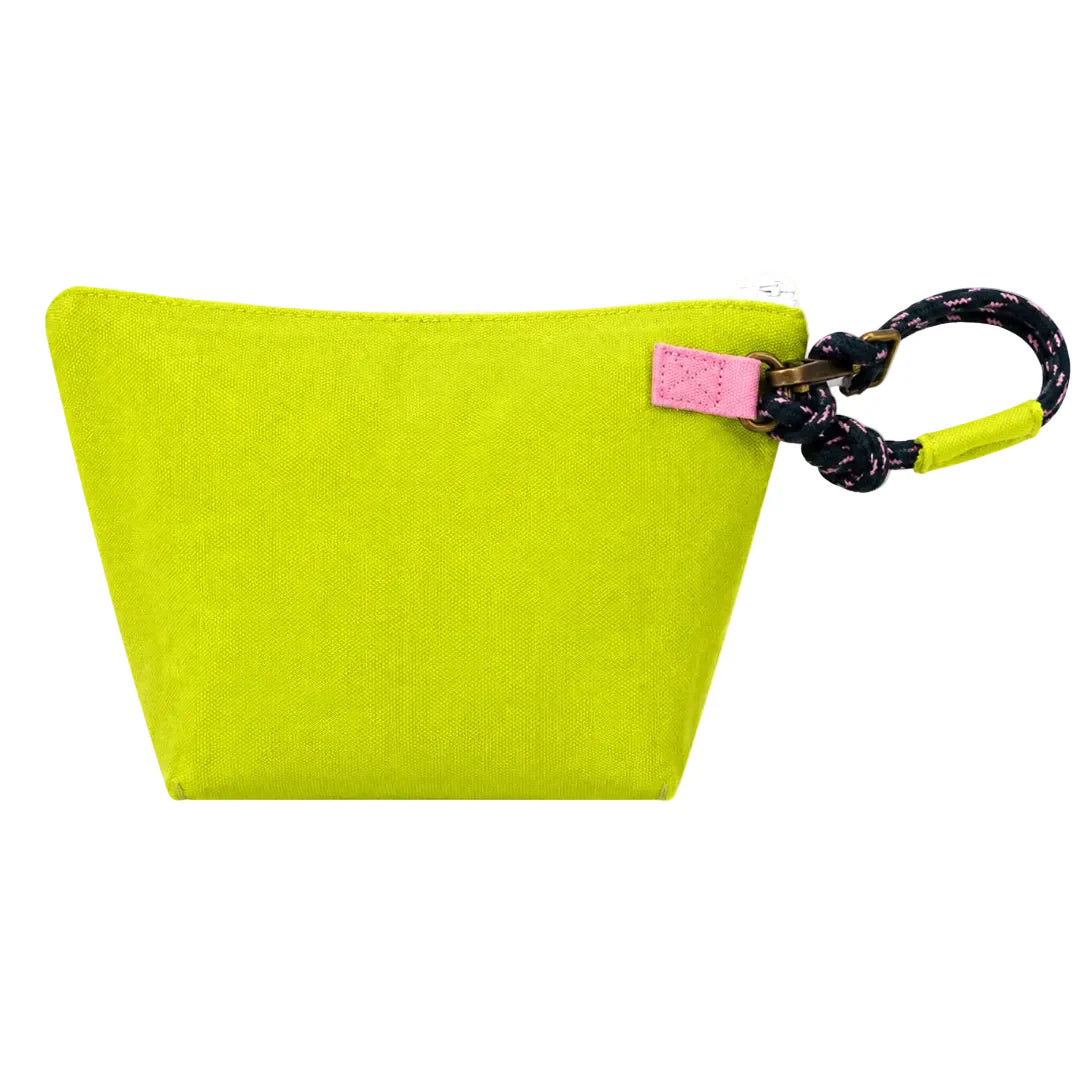 The KR Heart Wristlet by Kerri Rosenthal is a bright yellow, trapezoid cotton canvas pouch featuring a pink tag and a black and pink knotted rope handle on the top right corner.