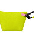 The KR Heart Wristlet by Kerri Rosenthal is a bright yellow, trapezoid cotton canvas pouch featuring a pink tag and a black and pink knotted rope handle on the top right corner.