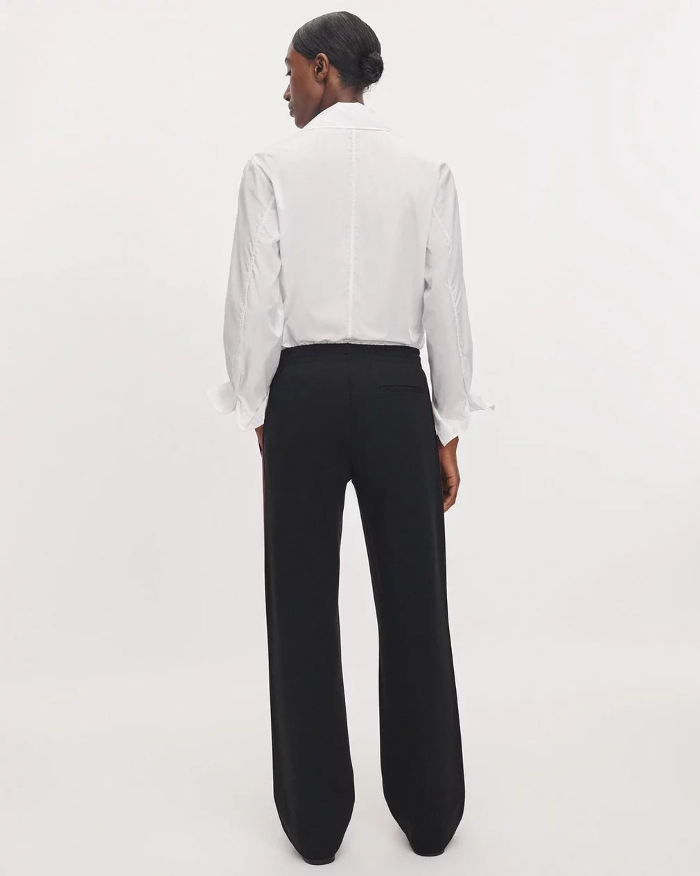 Irina Ponte Track Pant in black worn with a white button-down shirt, back view.