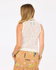 A woman with long, wavy blonde hair is shown from the back wearing the Kerri Rosenthal James Sweater Tank and a tan skirt with embroidered shapes and words, standing against a plain white background.