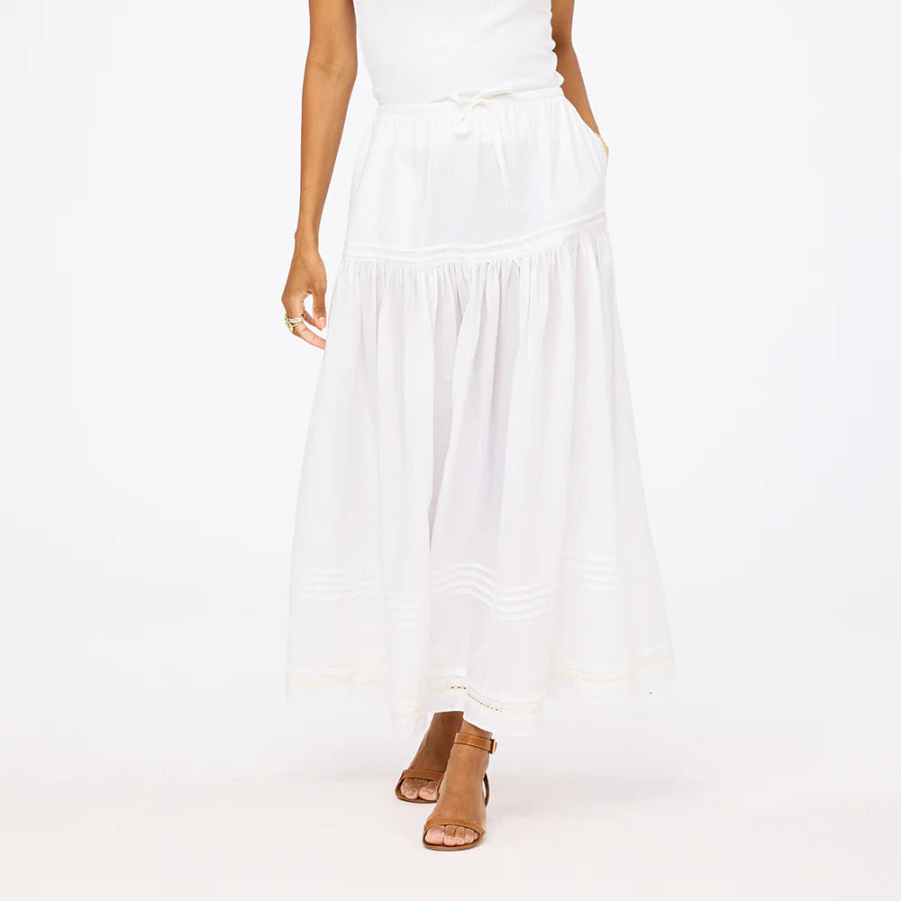 White Kerri Rosenthal Vacance Pintuck Shirt with lace-trim midi skirt and brown heeled sandals in a casual setting.