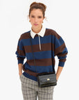 Black croco-embossed Italian leather Kathryn crossbody bag by Clare Vivier worn with a striped polo.