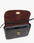 Black croco-embossed Italian leather crossbody bag with open flap, burgundy lining, and gold clasp by Clare Vivier.