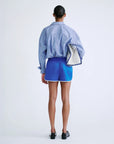 FRANKIE mid-waist shorts by Love Stories in a casual lifestyle setting with blue striped shirt, white clutch under arm.