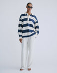 Striped cotton rugby shirt by Love Stories styled with white pants and sandals, relaxed hand-in-pocket look.