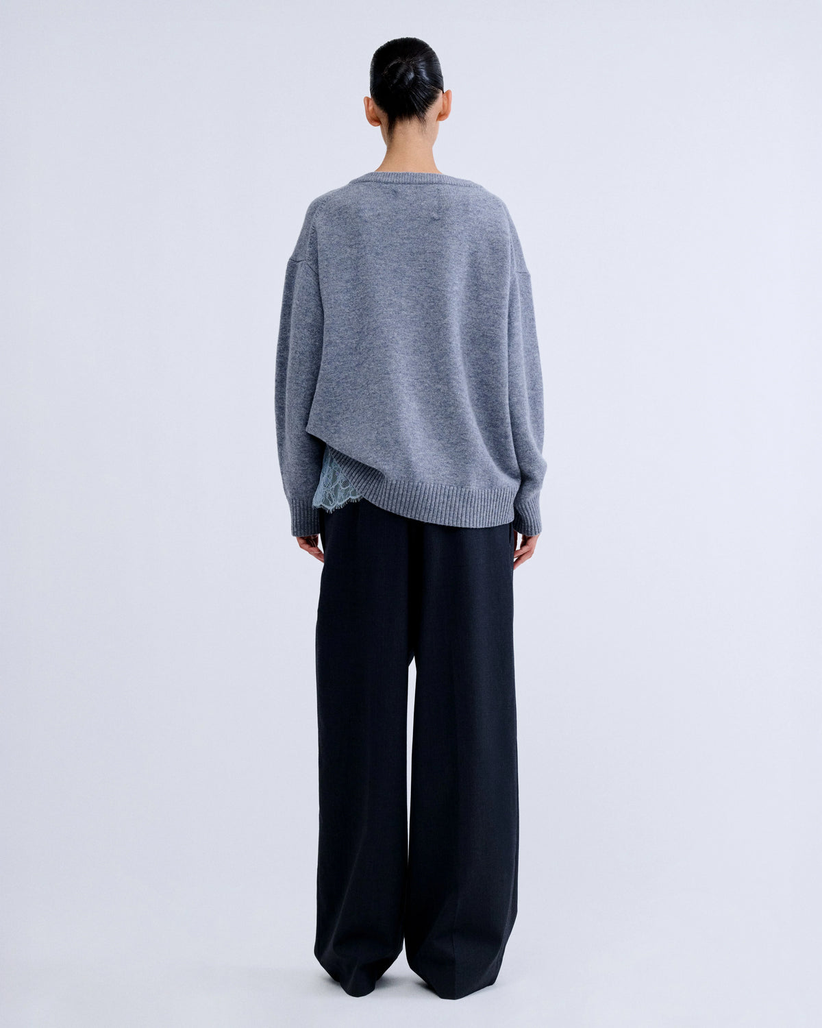 RACHEL white wool blend crewneck sweater with light blue lace hem worn over dark wide-leg trousers, back view.