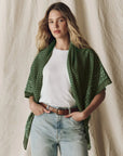 The Big Bandana draped over shoulders, featuring a large vintage green handkerchief with a white floral pattern.