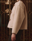 Woodside Toggle Coat by The Great Inc. in a classic style, shown indoors with ornate ironwork in the background.