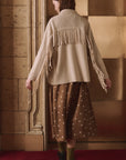 Western Fringe Sweater Jacket by The Great Inc., cream with fringe, styled with a brown polka dot skirt on red carpet.