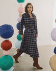 Dorrington Jacket by Hunter Bell NYC styled with brown boots, vibrant paper spheres create a playful lifestyle setting.