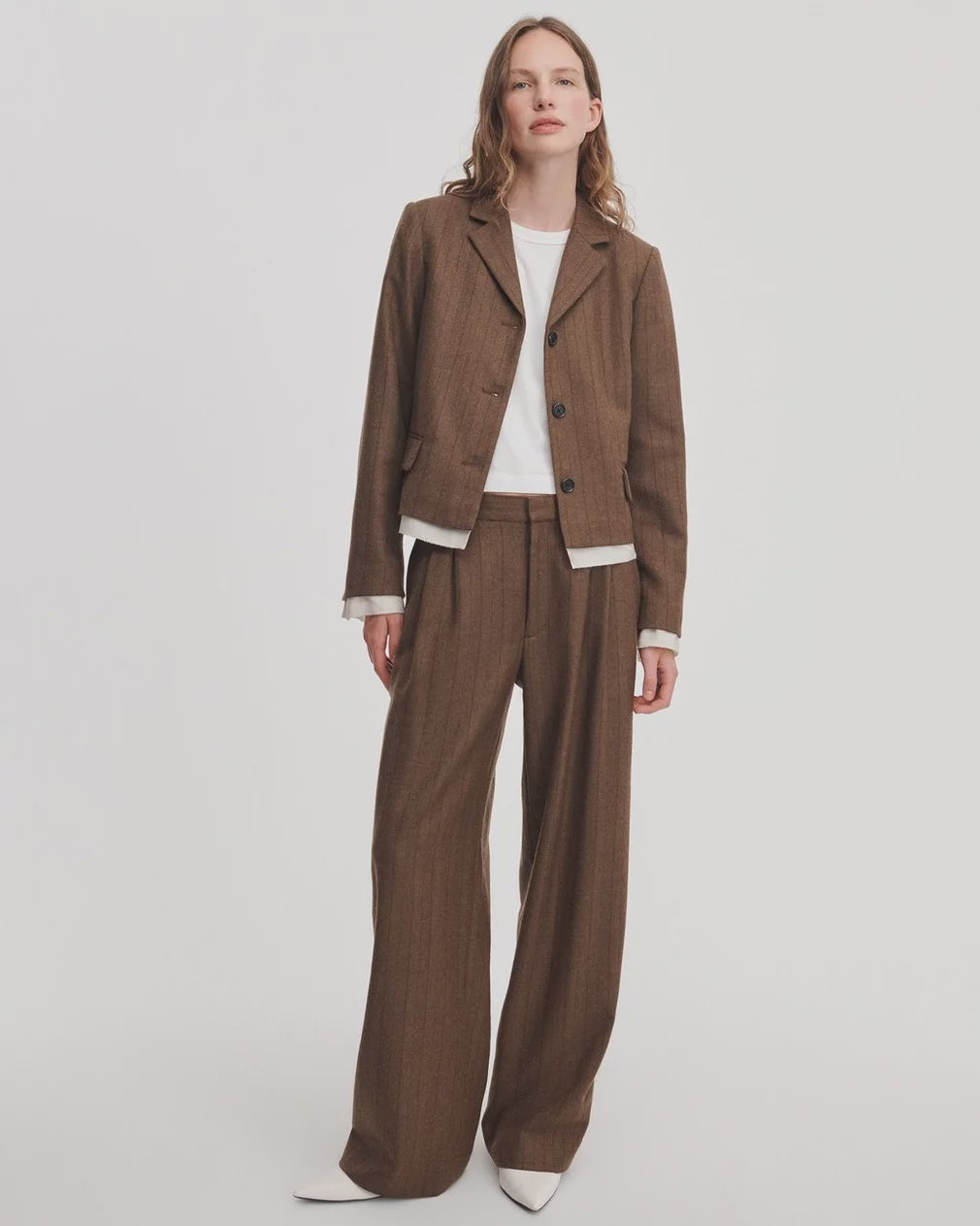 Brown pinstriped blazer and Lawrence tailored pant with white shirt worn by model.