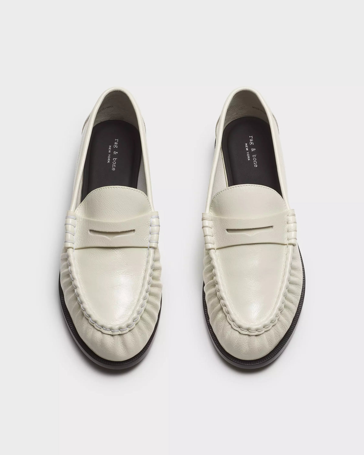 The Rag & Bone lexi loafer is a white slip-on with rounded toes and stitched details, featuring OrthoLite foam insoles for comfort, shown side by side on a light background.