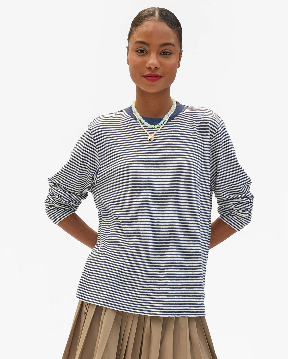 Clare Vivier blue and cream striped long sleeve tee styled with a pleated skirt, casual modern look.
