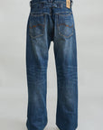 Loose indigo denim jeans with brown tag and visible pockets, back view; Denimist ALLFIT JEAN at Bungalow.