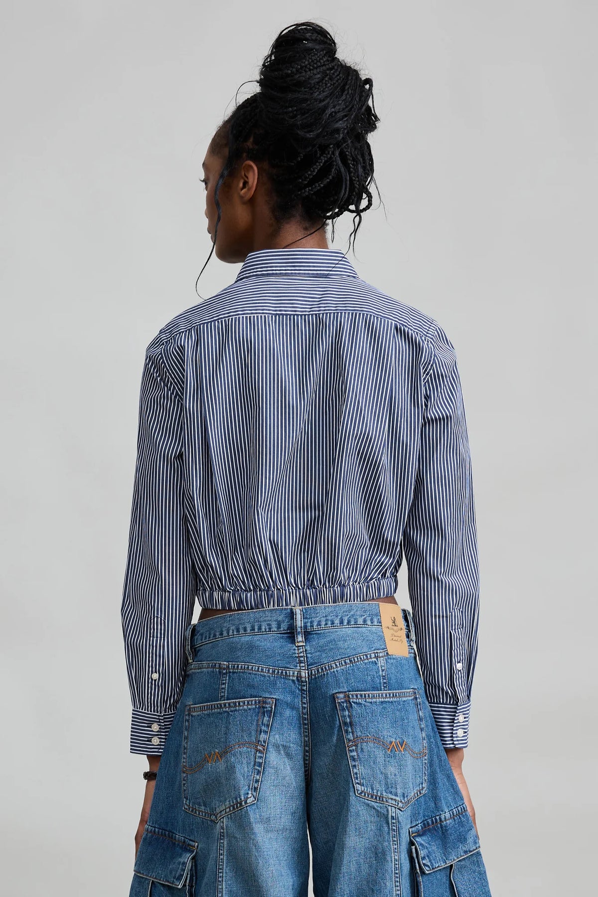 Denimist cropped elastic waist shirt and blue cargo jeans, back view, plain background, casual style.