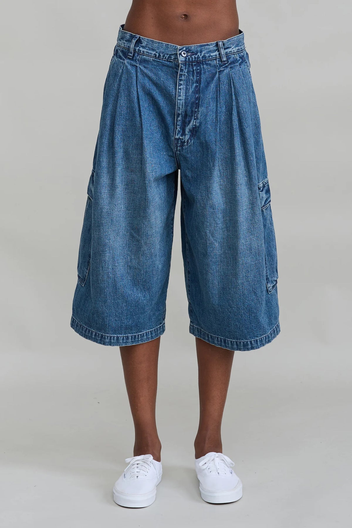 Ainsley triple pleat cargo shorts with oversized flap pockets by Denimist, styled with white sneakers.