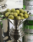 Nickel Zodax Condiment Bowl S filled with green olives on a reflective cocktail surface.
