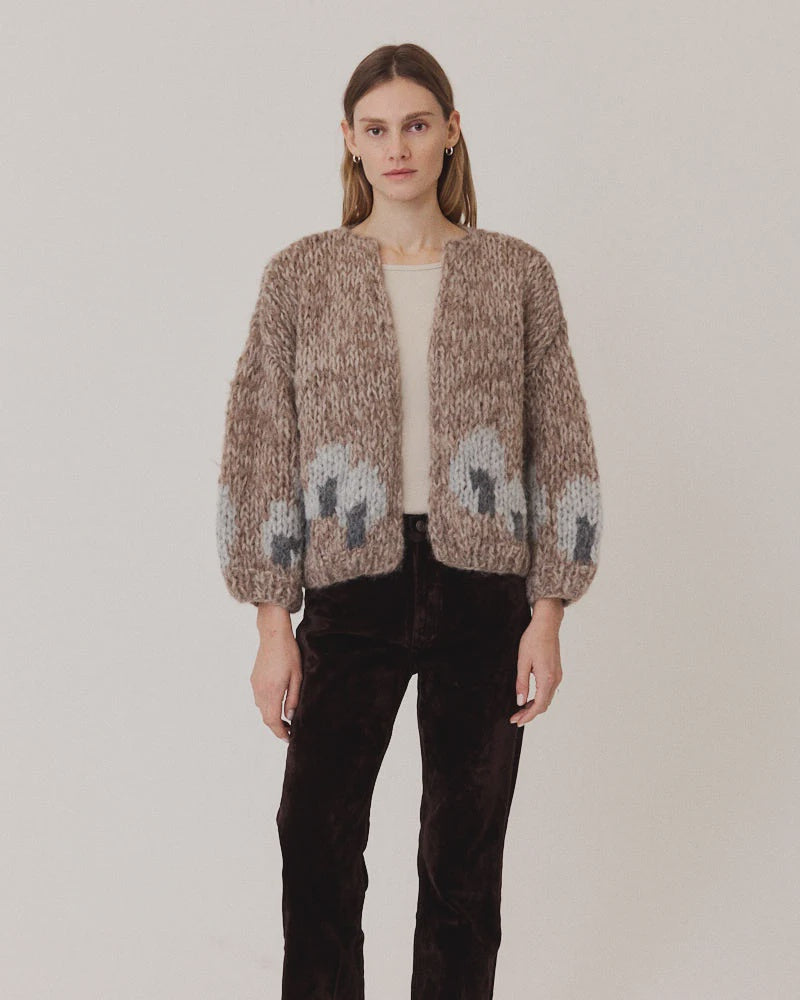 Maiami Fleecy Alpaca Intarsia Bomber Cardi in beige and grey worn over a beige top and dark brown trousers.