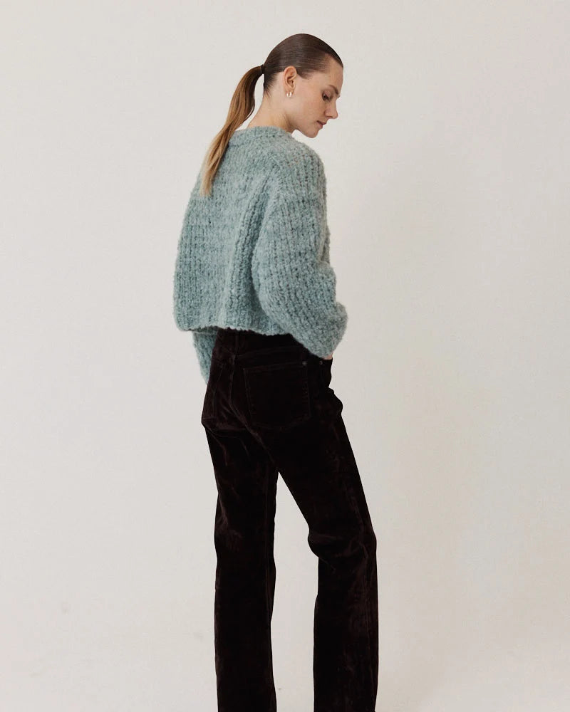 Maiami Wool Alpaca Mix Cropped Pullover in light blue worn with dark corduroy pants.