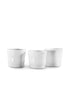 Three Tumbler No. 79 cups by Montes Doggett, crafted from high-fired white ceramic with a subtly ridged, handmade look, are shown side by side on a plain white background. They are both microwave and dishwasher safe.