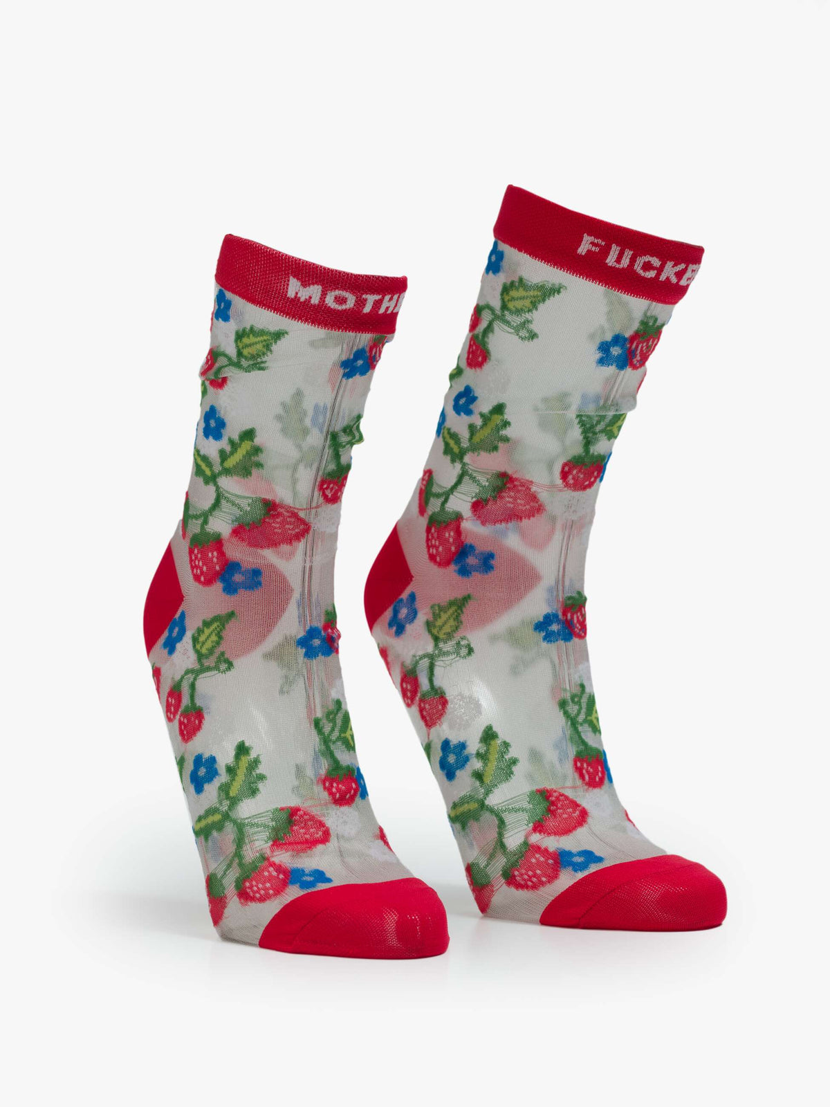 The Step Up Sock by Mother features translucent grey fabric, red toe, heel, and cuff, with colorful strawberry and blue flower designs. The cuffs display "MOTHER" and "FUCKER" woven in white.