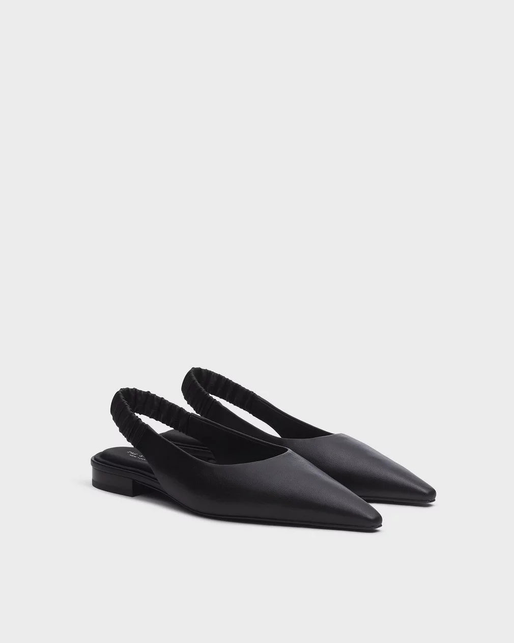 The Rag & Bone mercer slingback flat—a pair of black leather pointed-toe flats with cushioned footbeds, elastic back straps, and low heels—is displayed on a white background.