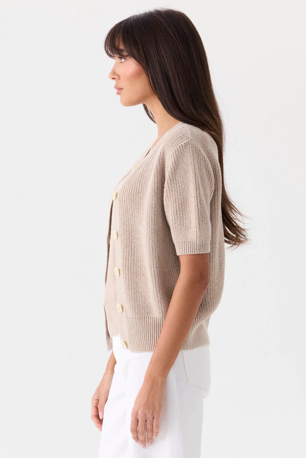 Beige short-sleeved Mia Fratino Cashmere Rue Relaxed Cardigan with a button-front closure worn by a woman.