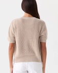 Rue Relaxed Cardigan in beige organic cotton short-sleeve knit, back view, paired with white pants.