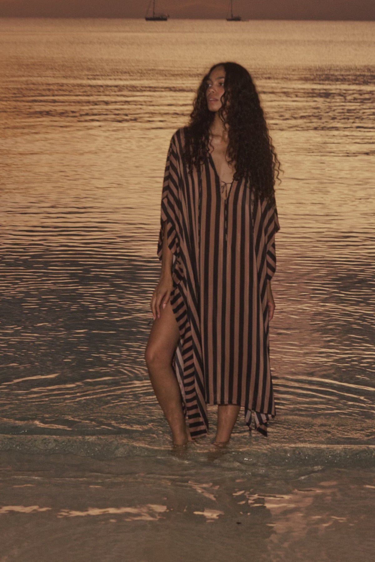 Natalie Martin Paulina Caftan in sunset light, styled oceanside with sailboats for a breezy, relaxed look.