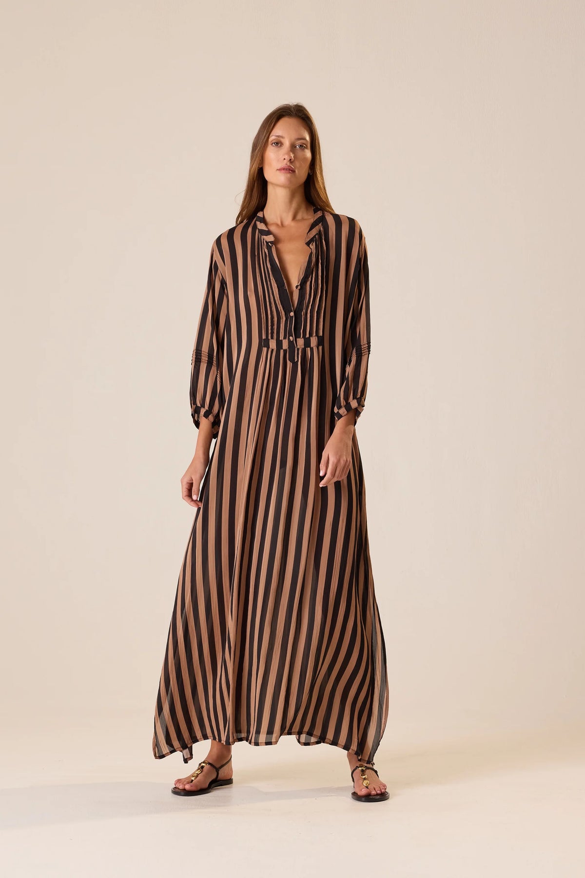 Sammie Maxi Dress in Thick Stripe Black Tan by Natalie Martin, v-neckline, styled with sandals on a light background.