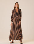 Sammie Maxi Dress in Thick Stripe Black Tan by Natalie Martin, v-neckline, styled with sandals on a light background.