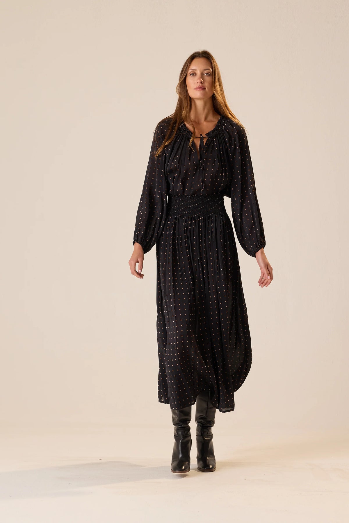 Bella Skirt by Natalie Martin in black with white dots, styled with black boots, lifestyle setting.