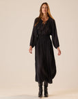 Bella Skirt by Natalie Martin in black with white dots, styled with black boots, lifestyle setting.