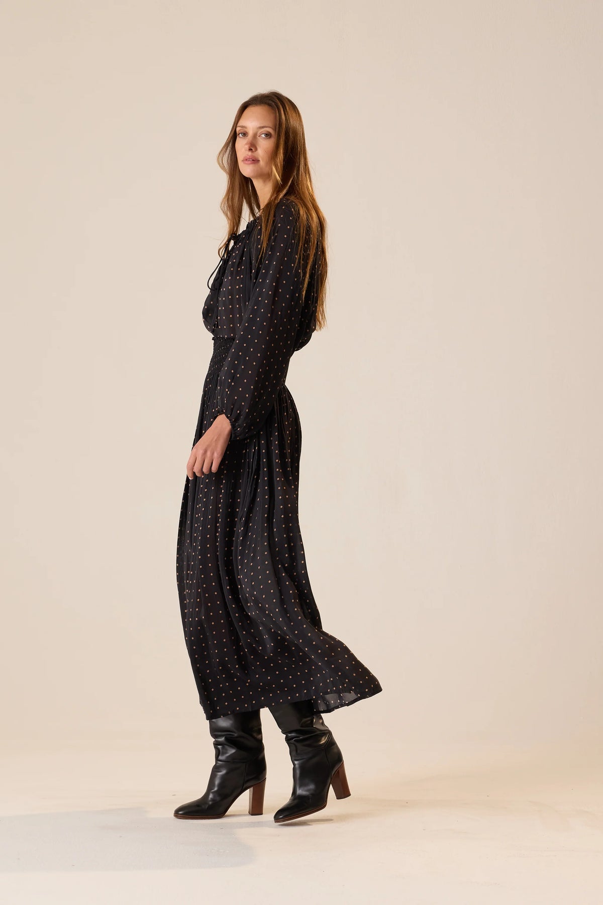Bella Skirt by Natalie Martin in a vintage 70s style, paired with boots, styled against a beige backdrop.