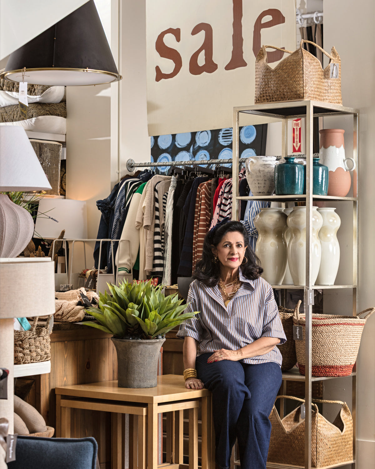 Relaxed lifestyle scene in Bungalow Furniture, featuring baskets, vases, greenery, and a sale display.