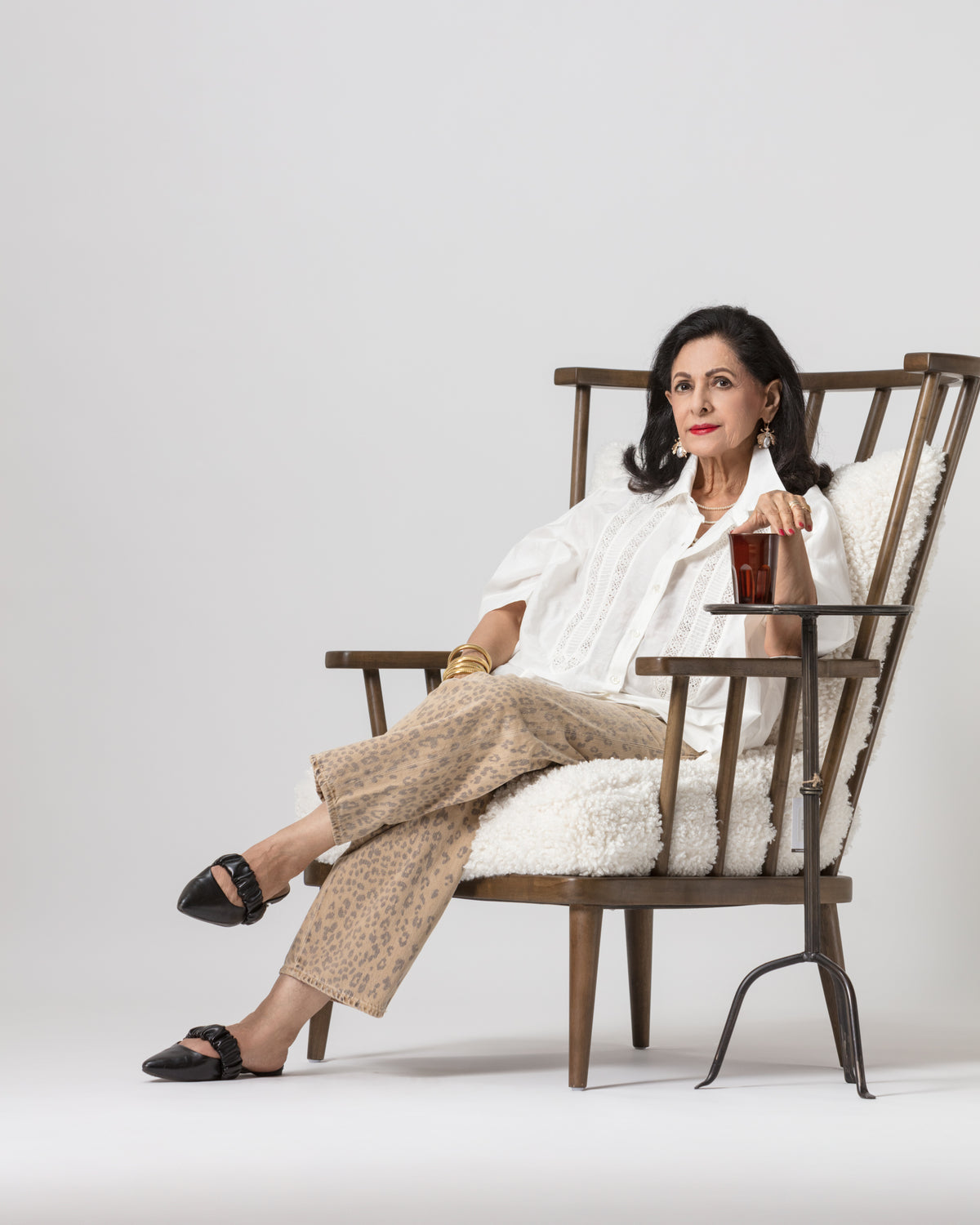 Patterned pants styled with a white blouse, Bungalow Furniture, relaxed neutral setting with wooden chair.