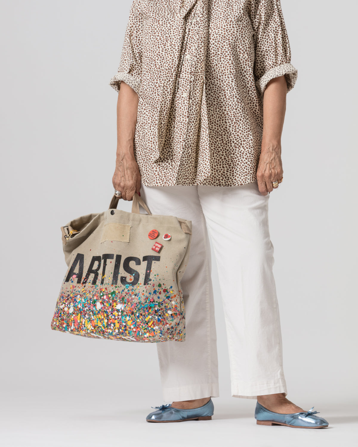 Colorful tote bag with a playful spotted blouse and blue flats, styled for an artistic, vibrant Bungalow vibe.