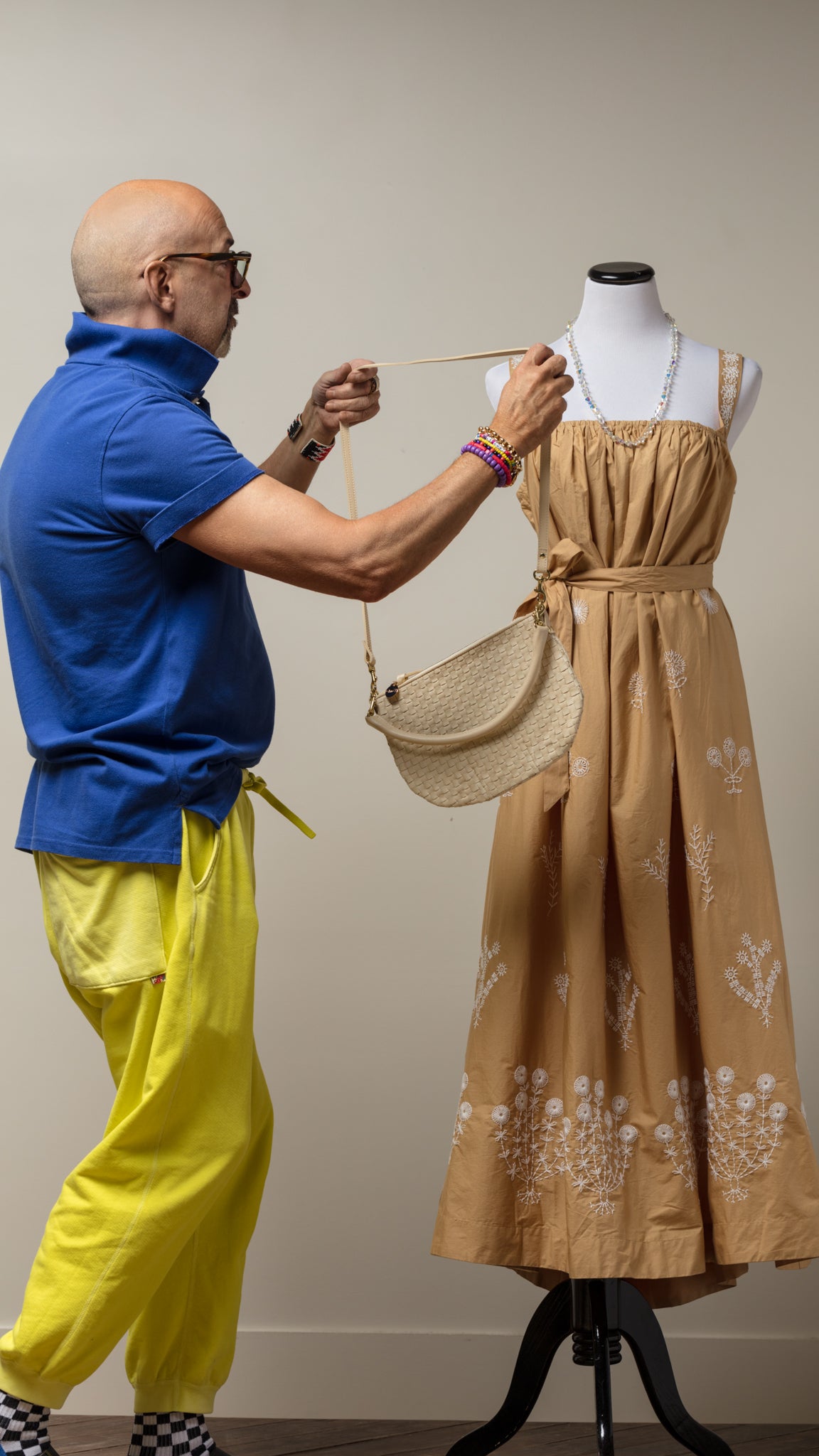 Tan floral dress on mannequin styled with a woven purse, Bungalow Furniture & Accessories display.