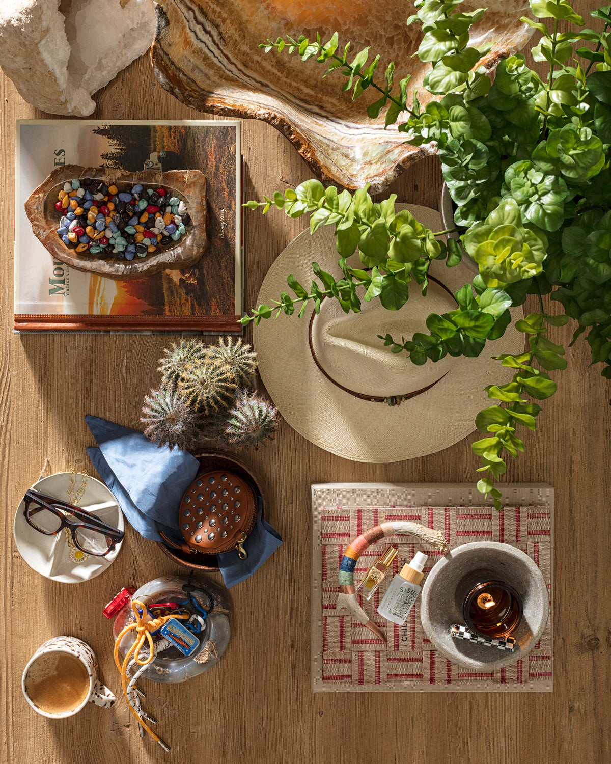 Eclectic Bungalow decor with hats, books, plants, and colorful accents styled on a rustic wood table.