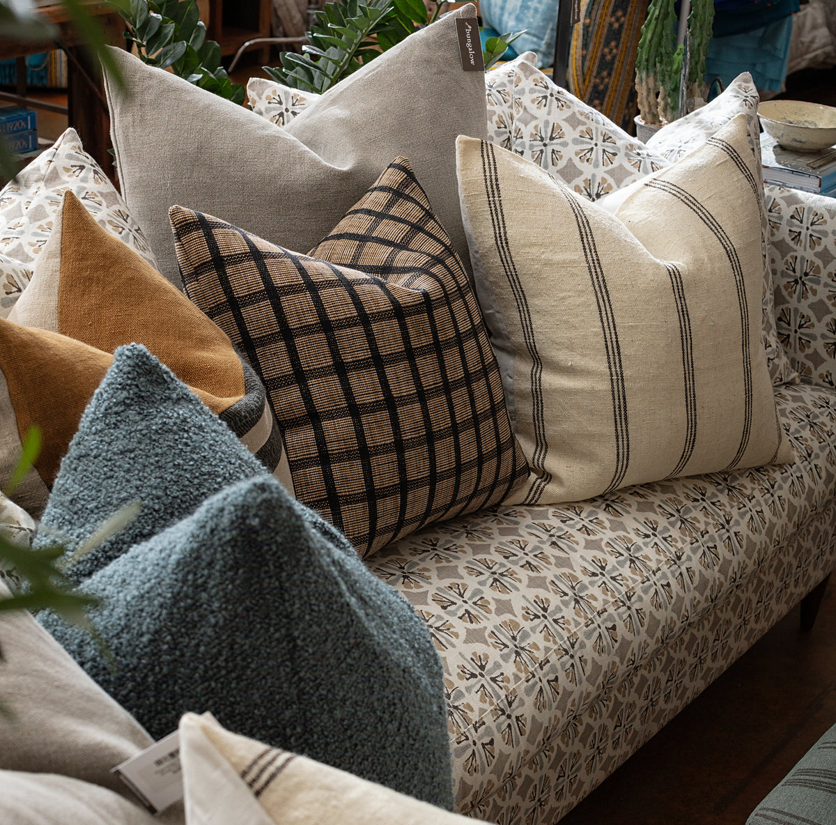 Patterned sofa with colorful striped and checked pillows, Bungalow Furniture & Accessories, modern living room style.