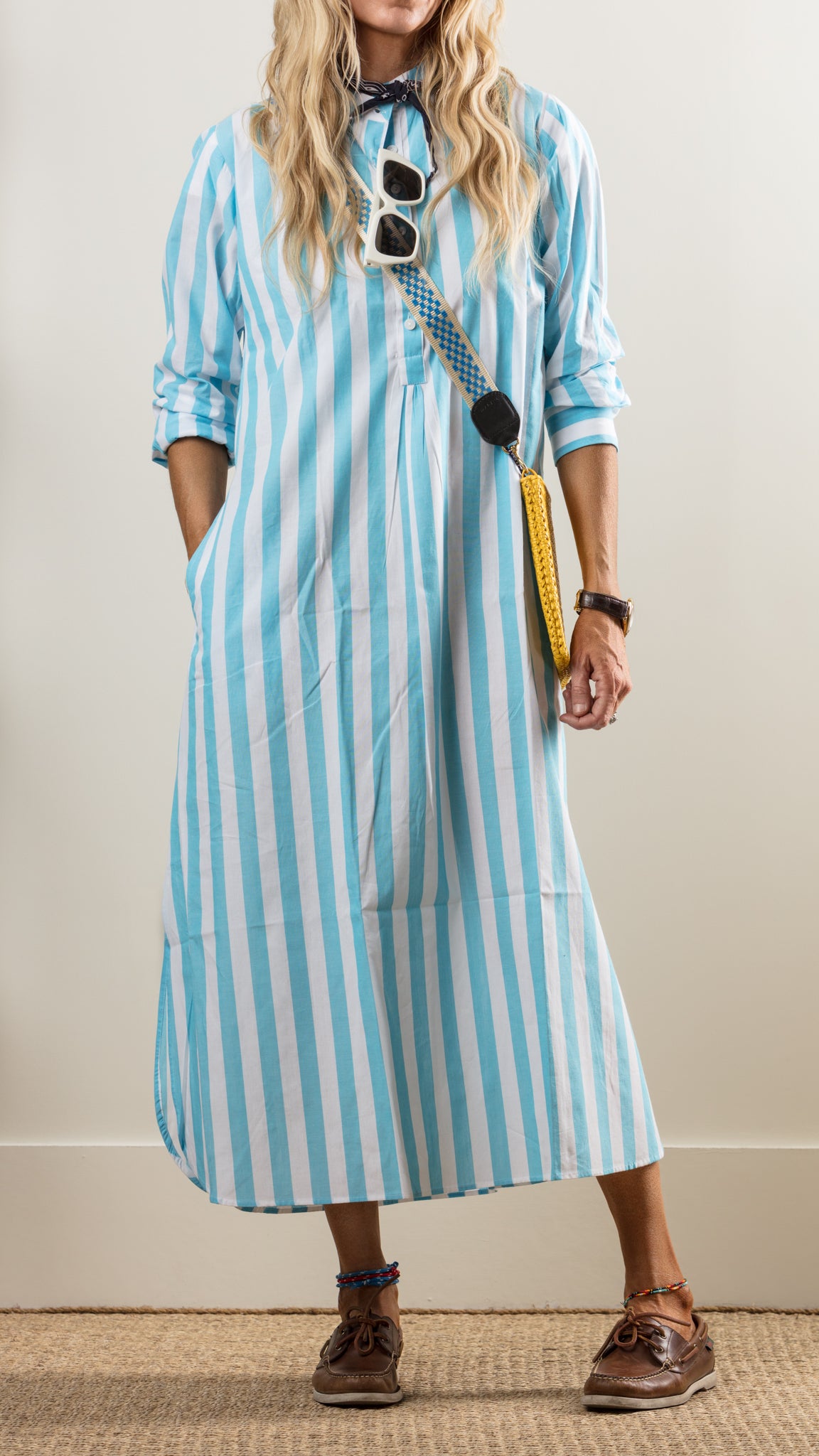 Blue and white striped maxi dress with brown shoes, crossbody bag, and casual summer style.