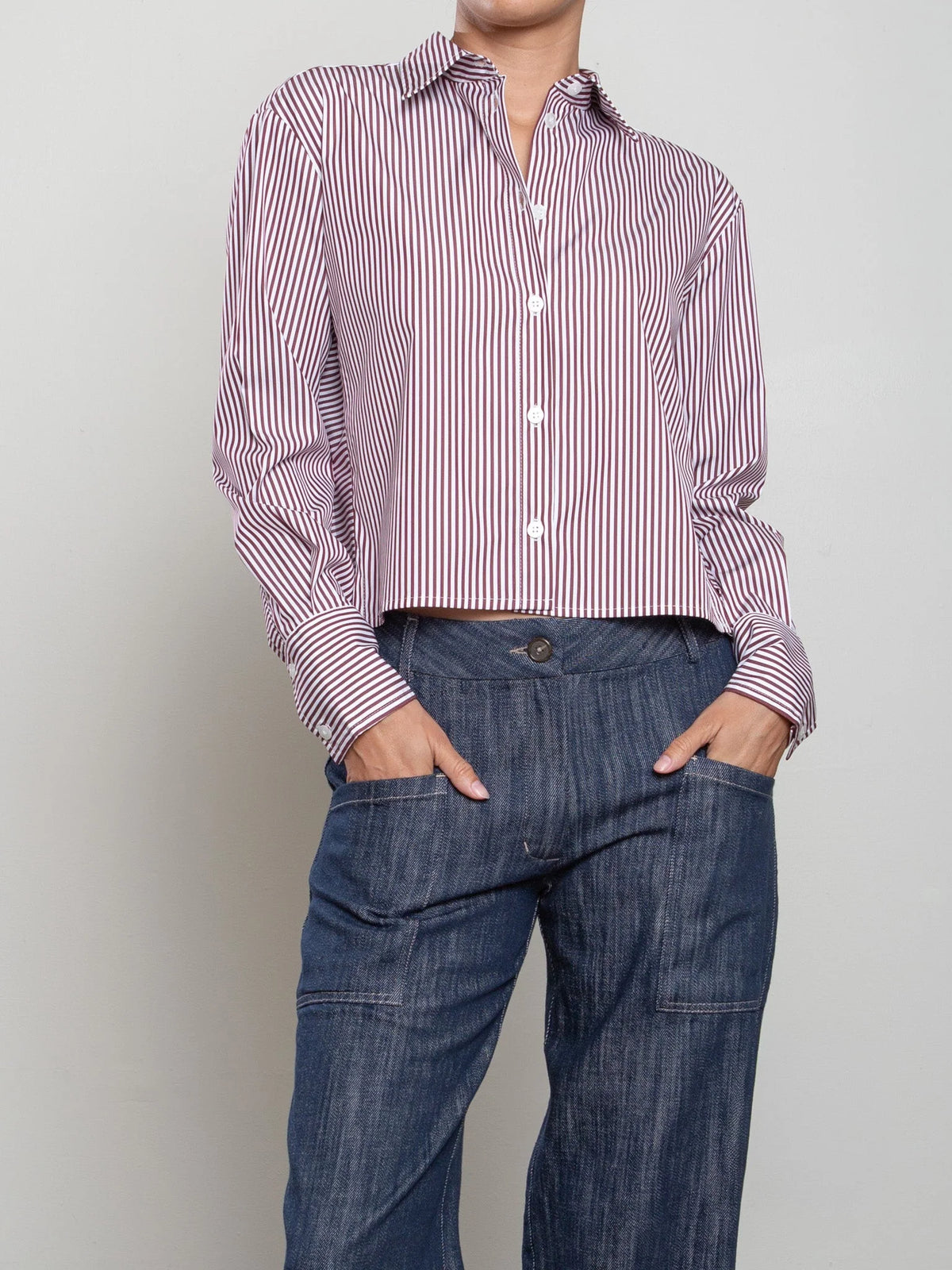 Pharaoh’s Enzo striped poplin shirt in blue, styled with jeans, hands in pockets, simple background.