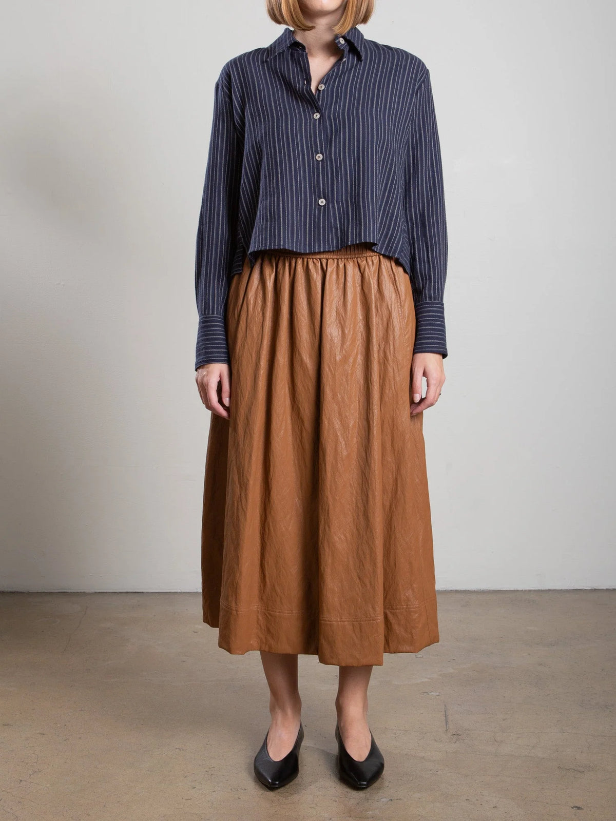 Pharaoh Claudia chestnut faux leather skirt with navy striped shirt, interior setting, Bungalow Furniture & Accessories.