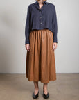 Pharaoh Claudia chestnut faux leather skirt with navy striped shirt, interior setting, Bungalow Furniture & Accessories.