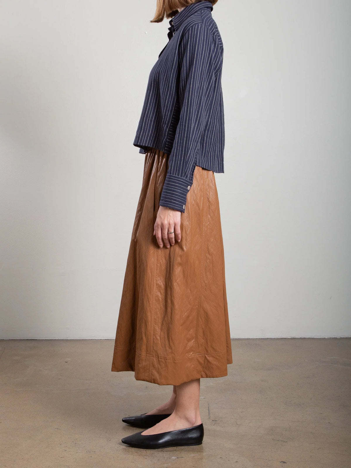 Brown Pharaohs Claudia Skirt with faux leather pockets, styled with a navy blouse and black flats.
