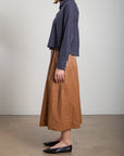 Brown Pharaohs Claudia Skirt with faux leather pockets, styled with a navy blouse and black flats.